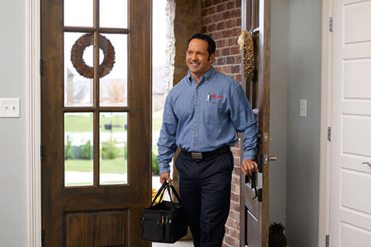 Trane technician walking in to a house 